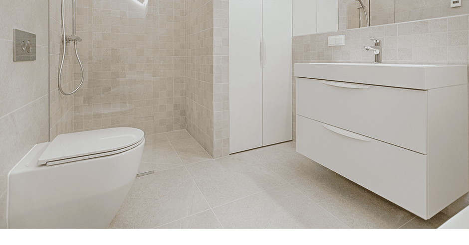 Badezimmer mit hochwertigen, hellen Fliesen am Boden und an den Wände verlegt