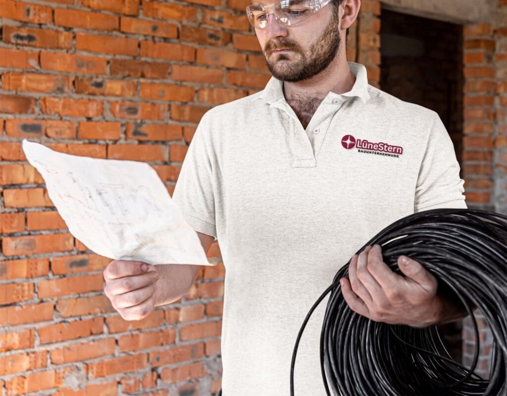 Mitarbeiter schaut sich Grundriss an auf einer Baustelle